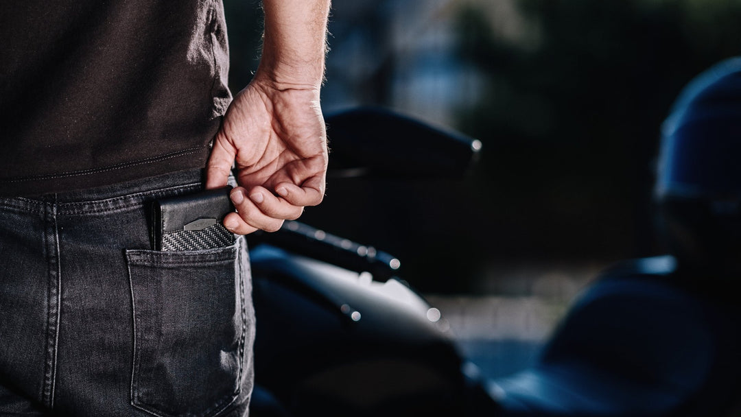 ColdFire wallet being pulled from back pocket, motorcycle in background